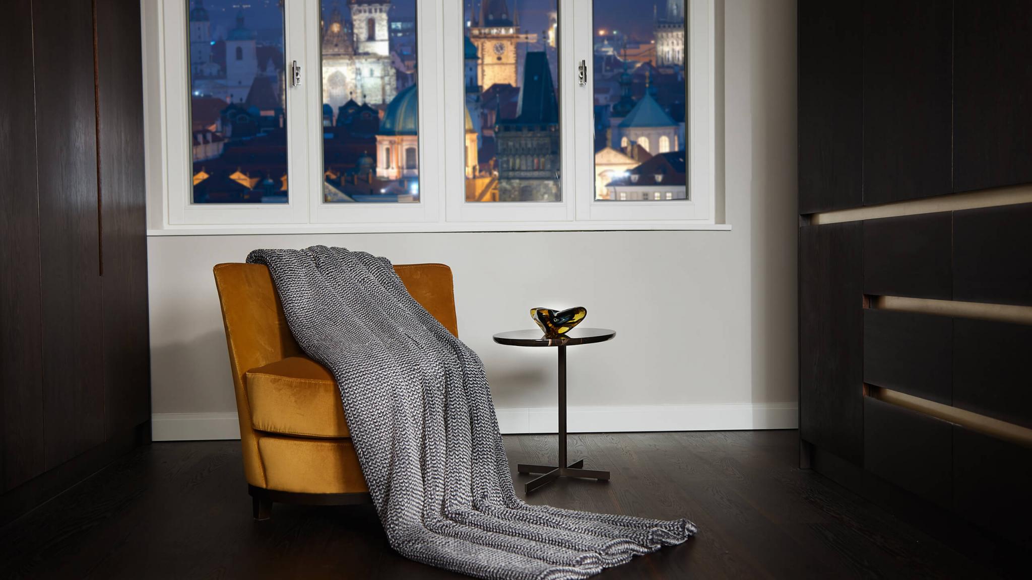 Cortina grau Pfeffer herrlich weiche kuschlige exklusive Webfelldecke Webfelldecke elegant in außergewöhnlicher Strickoptik auf gelben Sessel