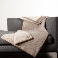Cortina Sand braun hellbraun herrlich weiche kuschlige exklusive Webfelldecke Webfelldecke elegant in außergewöhnlicher Strickoptik auf petrol Sessel